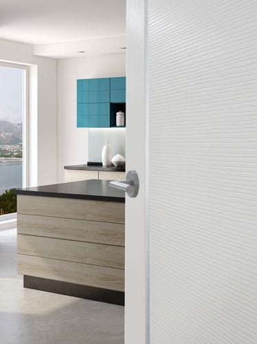 A white door opening up to a kitchen area overlooking a bay