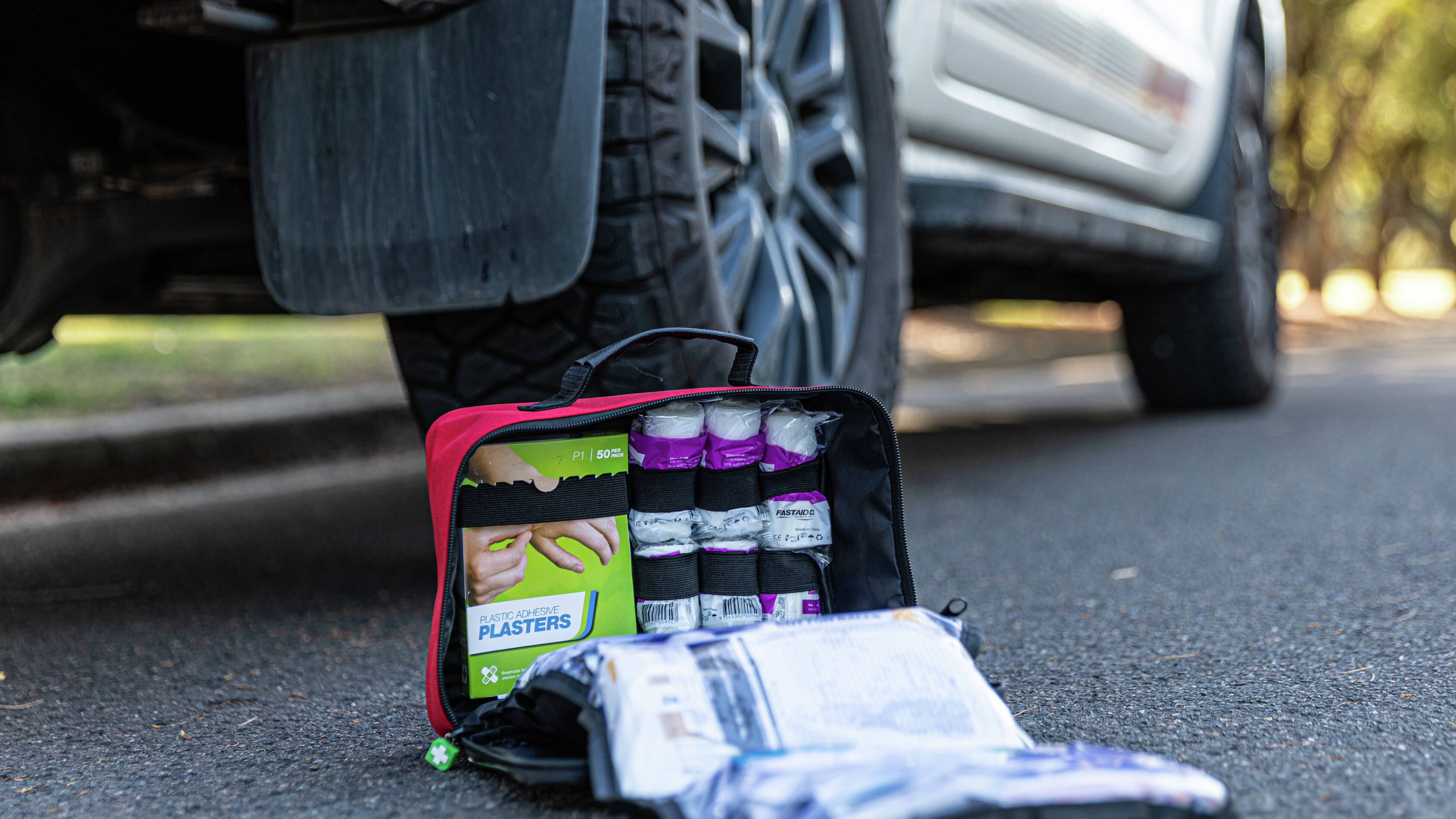 Fast aid kit rolled out next to a car ready to use if needed
