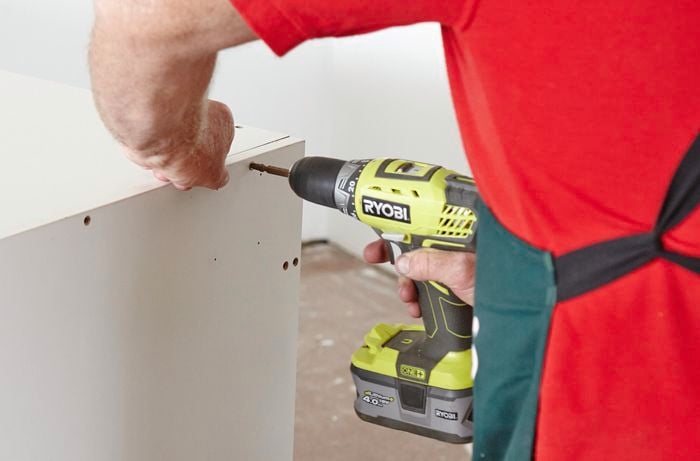 A Bunnings team member securing two panels of a pantry kit