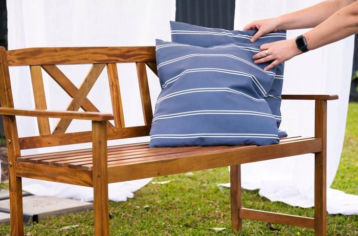 outdoor timber bench with two cushions