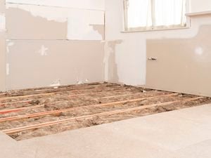 Insulation batts installed between floor joists.