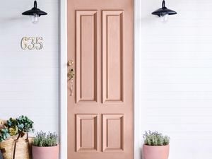 Light brown entrance door with brass locks and handle.