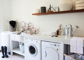 Laundry with washing machine, dryer, watering can and gumboots