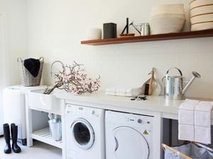 Laundry with washing machine, dryer, watering can and gumboots