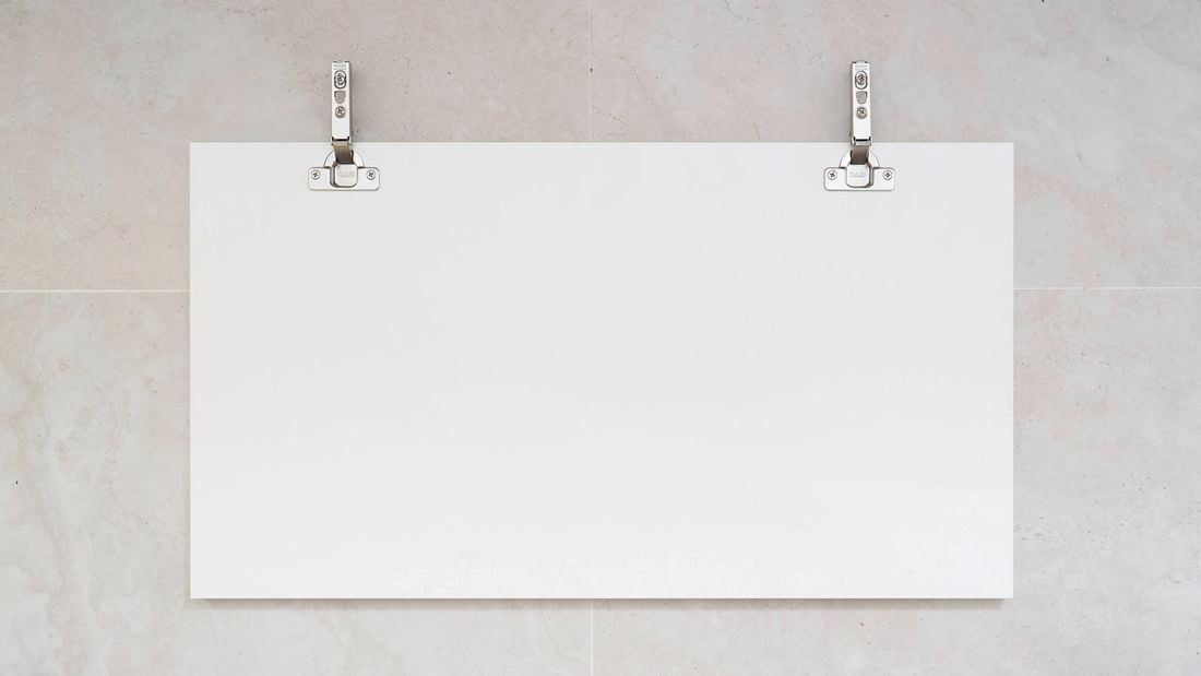 The image shows a cabinet door installed with metal hinges.  
