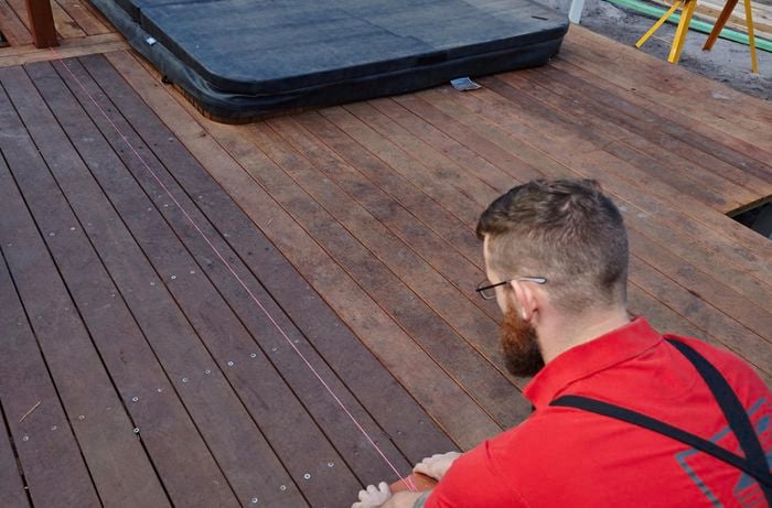 Person setting out string line on a deck.