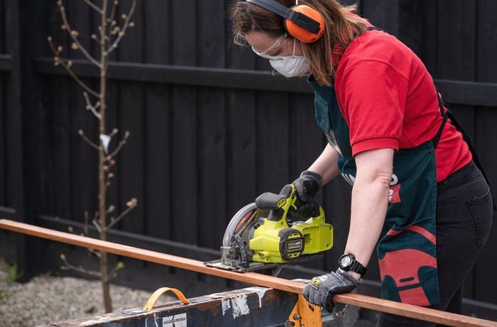 Person cutting the slats using electric saw.