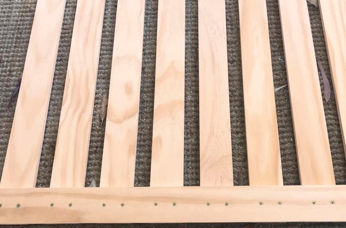 A slatted timber structure lying on carpet