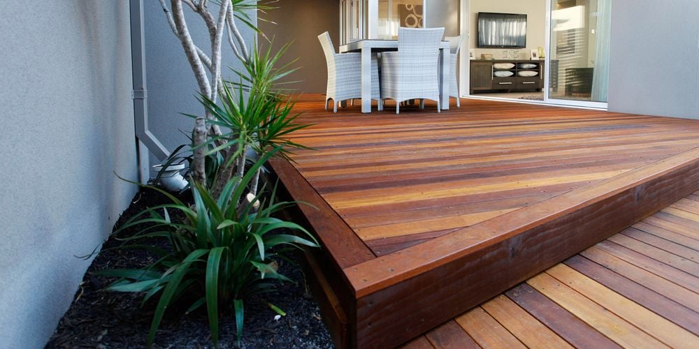 Large outdoor couch on deck with cushions.