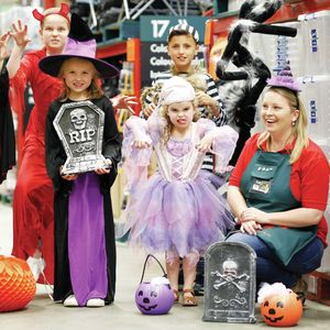 image of a store with team members and kids dressed in halloween costumes