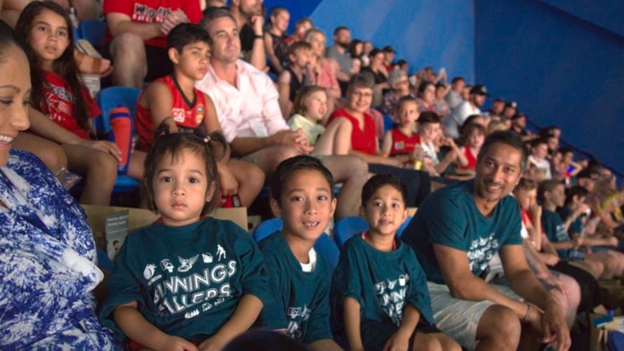 Family watching basketball game wearing Bunnings Backing Ballers tshirts