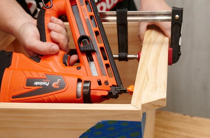 Person using nail gun to join up pieces of shadow box frame together.