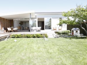 A white house with a front lawn and outdoor setting.