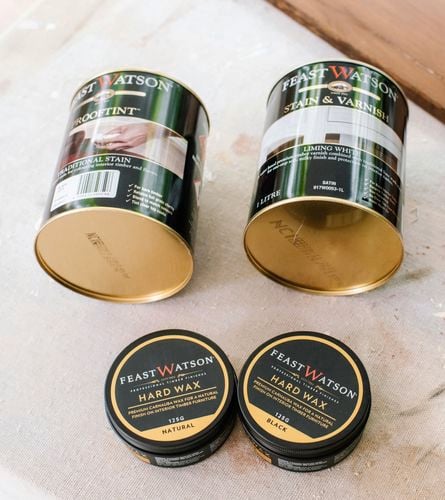 Paint tins and cans displayed on timber boards