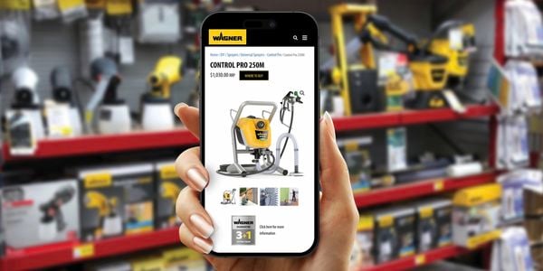 A person holding up their mobile phone screen on a Wagner spray gun product page.