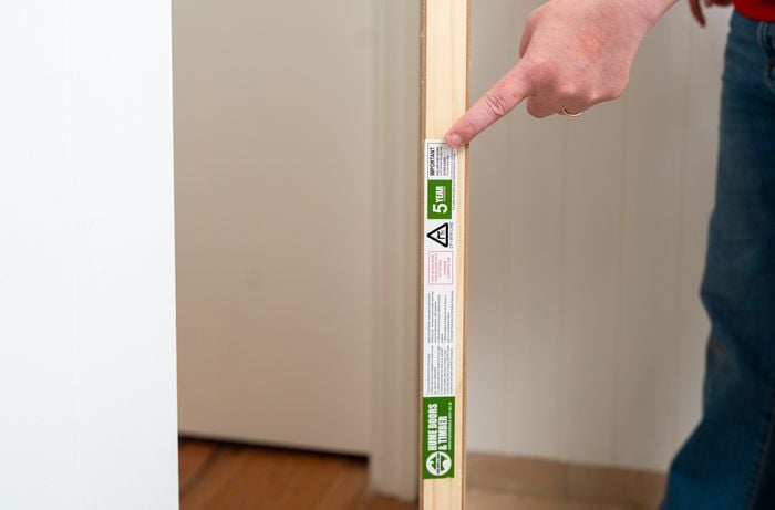 A person is checking the door size for accurate sizing, gap spacing, and smooth edges before installation. ​
