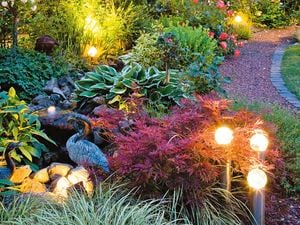 Garden lighting in an outdoor garden setting with decorative birds.