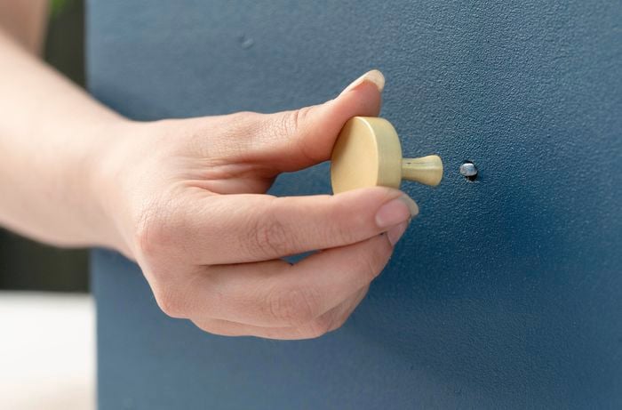 Screwing handles back onto wardrobe
