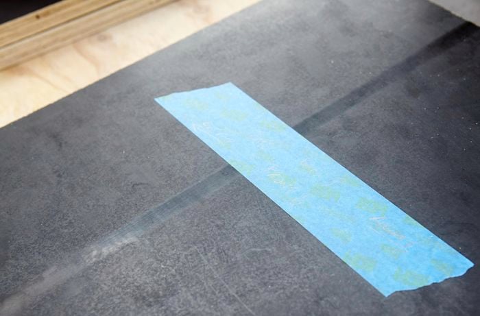 A piece of timber marked with blue tape to identify it as a side panel