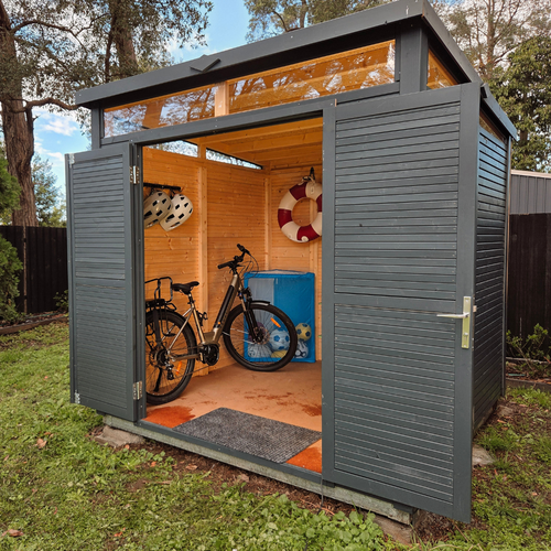 Modern charcoal bike and sports storage shed with windows and wide double doors, housing a bicycle and sporting equipment.