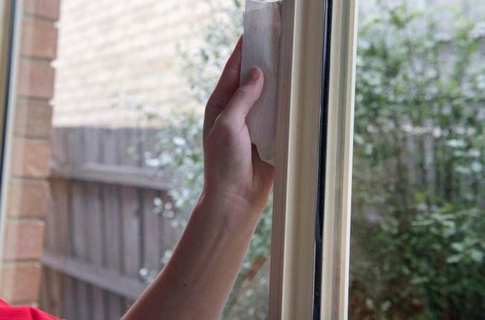 A painted window mullion being wiped clean