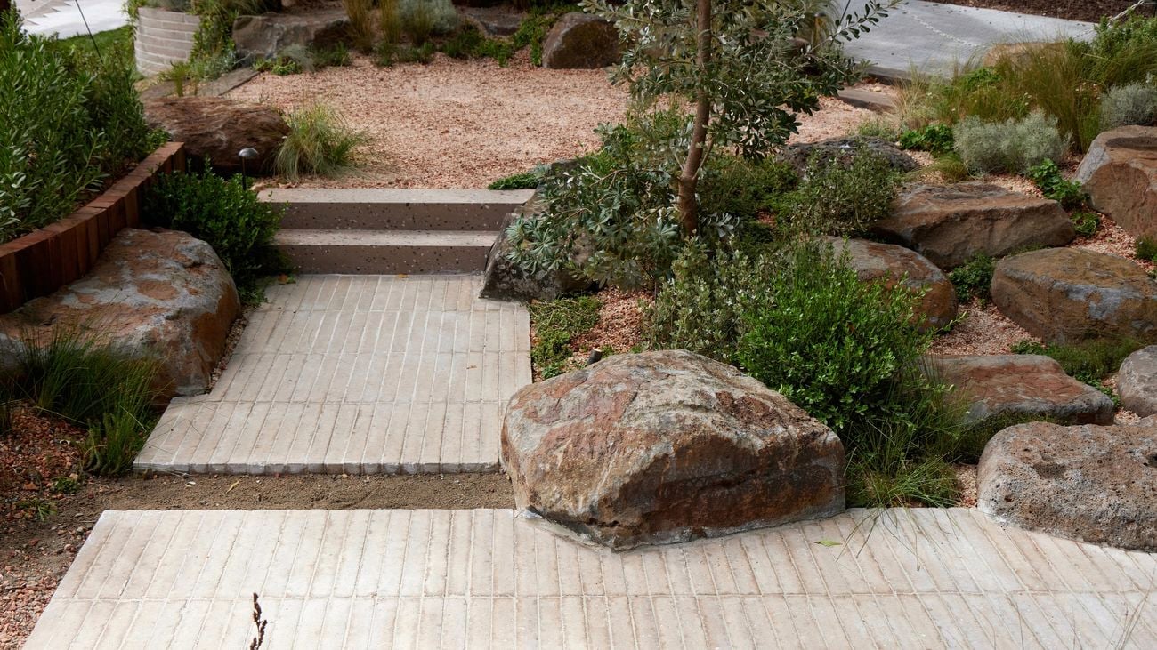 A diverse mix of materials including rocks, brick and stone pavers in a garden bed