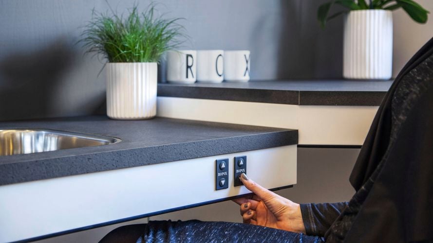 Person pressing button on adjustable height bench