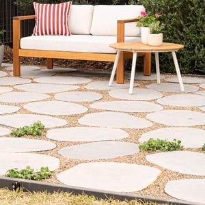 An outdoor patio showcases stepping stones with pebbles and greenery in between to fill the gaps