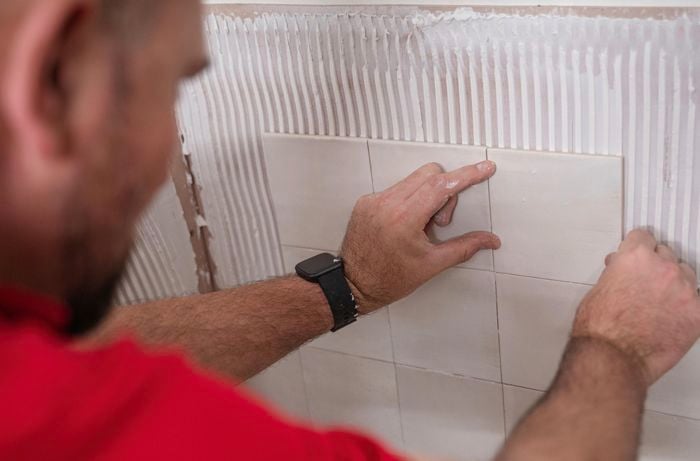 A person laying tiles.