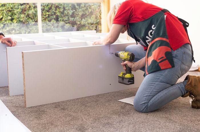 Person drilling into timber cabinet