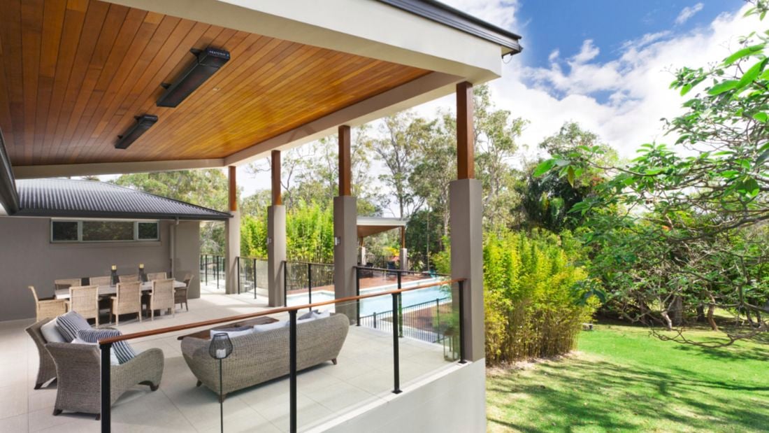 Outdoor lounge area with a black, Heatstrip heater attached to the ceiling.