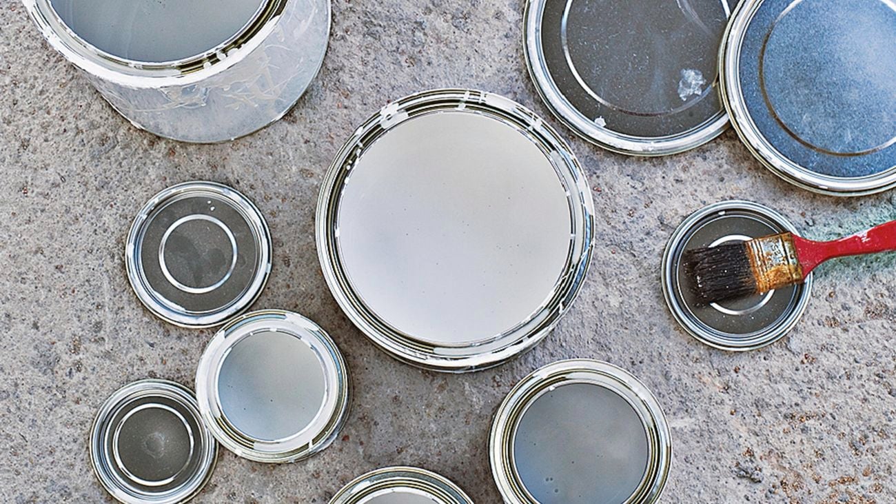 Empty paint tins and lids on the ground.