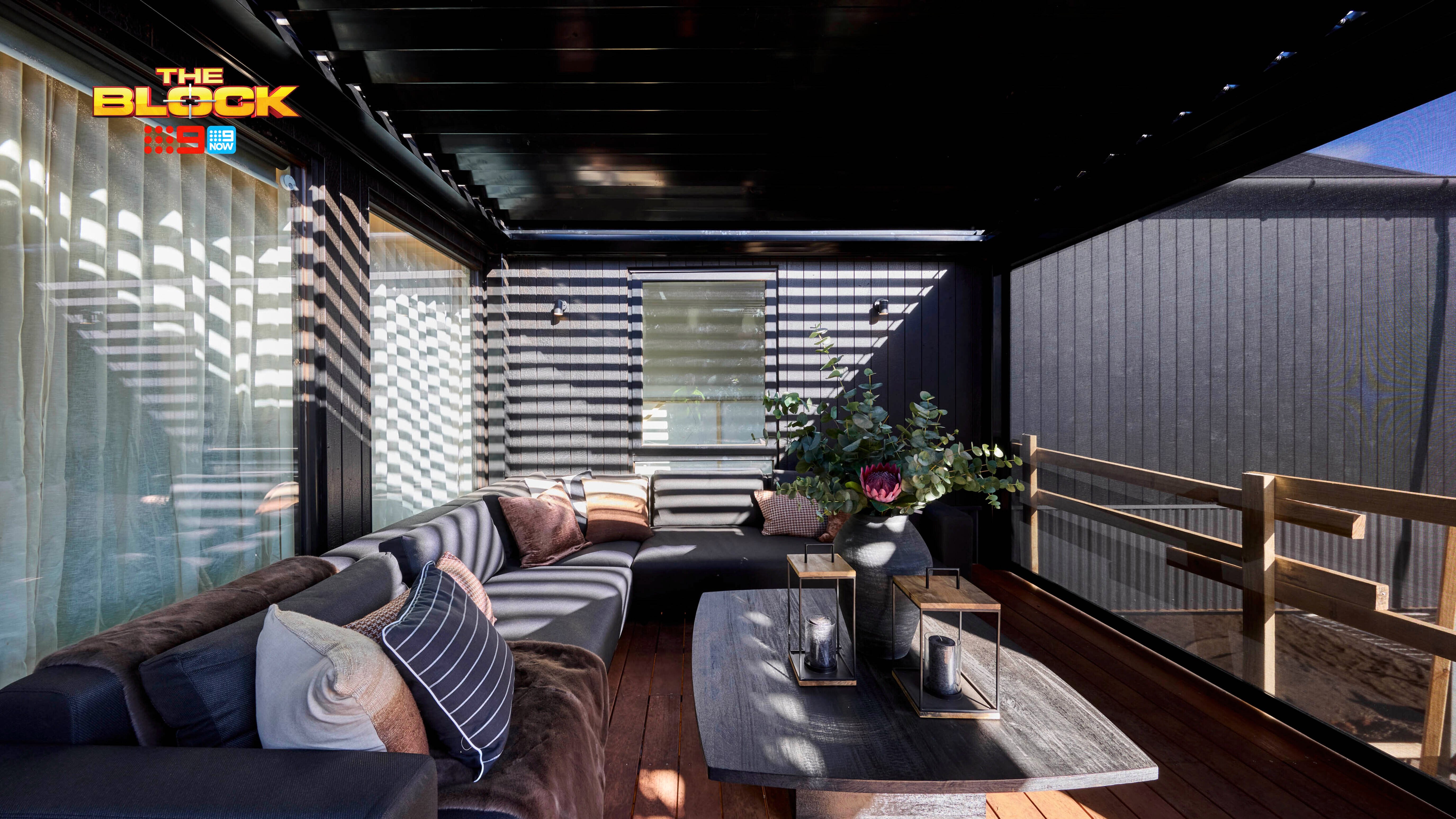 Outdoor area with a lounge and coffee table in it on decking.