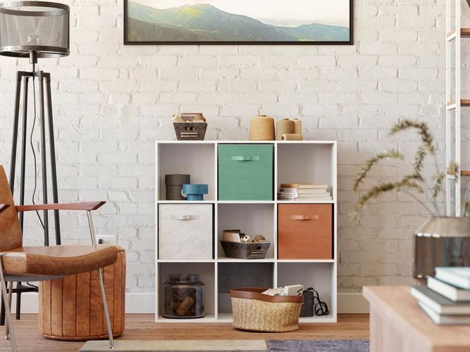 A cube shelving unit, a chair and a picture hanging on a wall in a lounge room