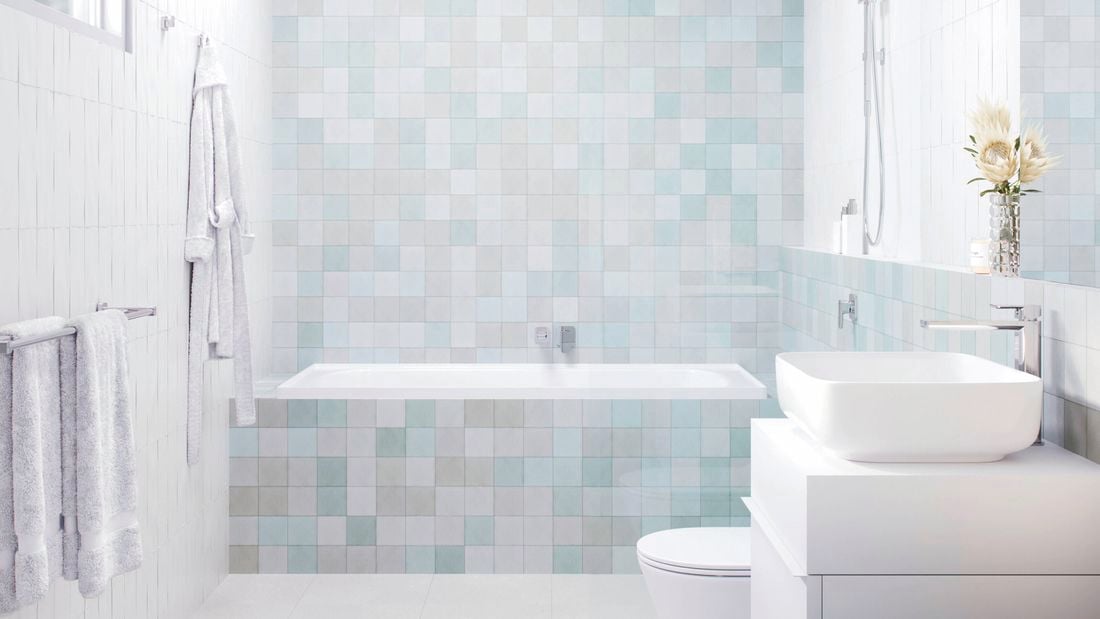 A modern bathroom with light-coloured tiles, featuring a skylight, shower, bathtub, vanity with a white basin, and a toilet.