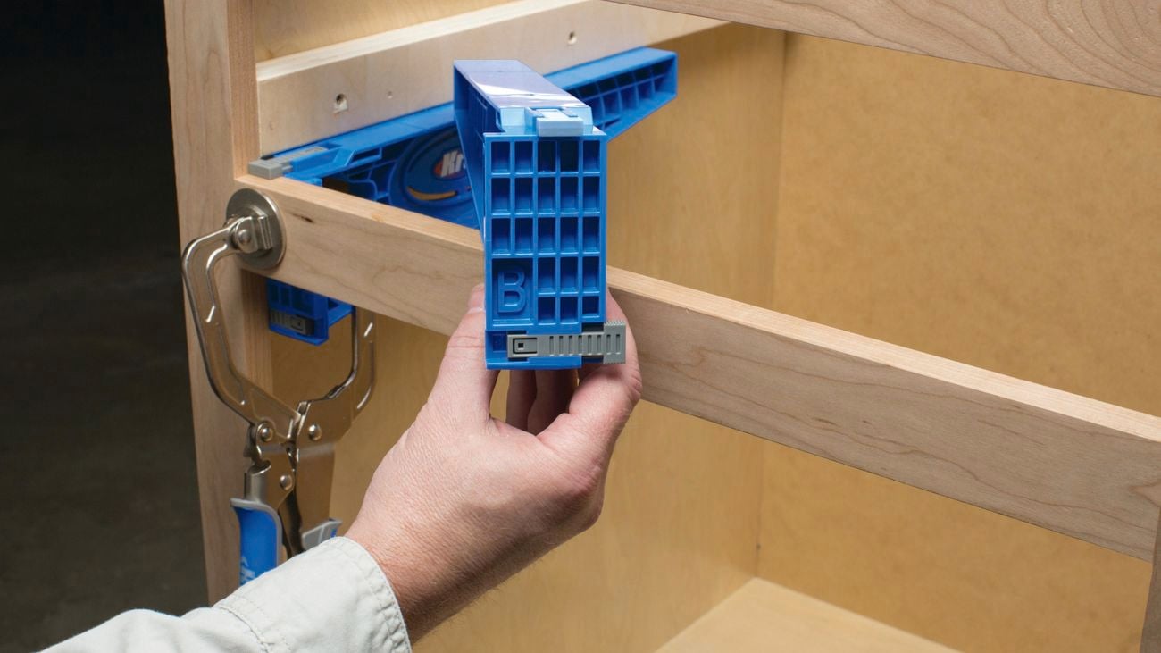 A person uses a Kreg drawer slide jig on a timber project