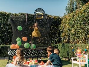 Girl on a trampoline at a kids party.