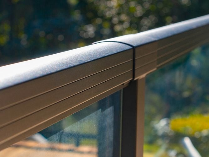 Close up of the black aluminium balustrade encasing glass panels.