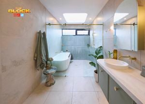 Green, gold and white coloured bathroom with a timber fluted profile vanity and marble benchtop and bath