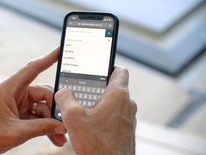 A person using their phone to look up products on the Bunnings Trade website.