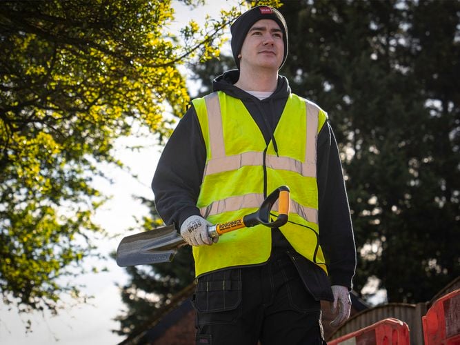 Tradie holding a Roughneck Micro Drainage Shovel on a worksite.