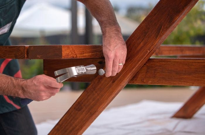 Hammering bolts in the bottom of each cross-rail and leg