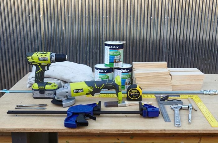Various tools and materials to build a wooden floor mat.