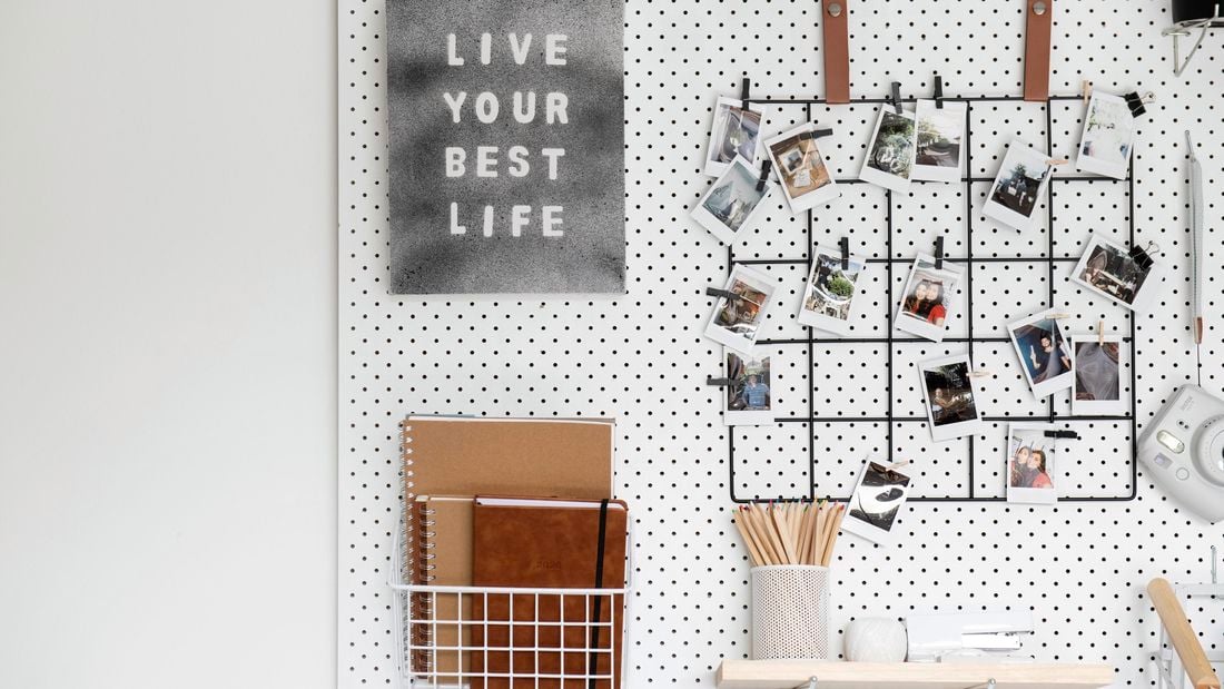 Pegboard with photos, craft tools and an inspirational quote on canvas