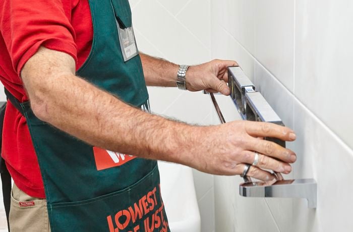 A person checking a towel rail with a spirit level