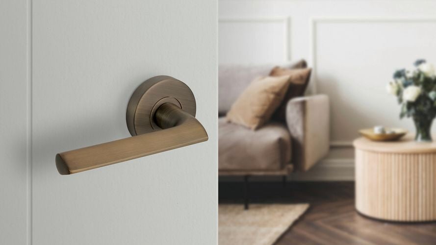 A bronze door handle from Delf on a white door