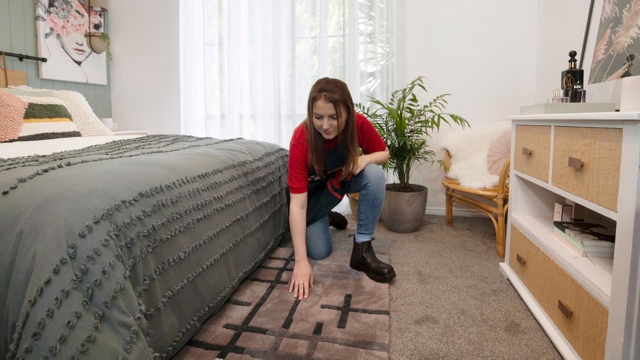 A decorative rug at the foot of the bed.