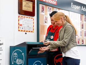 Bunnings team member helping a customer recycle her battery.