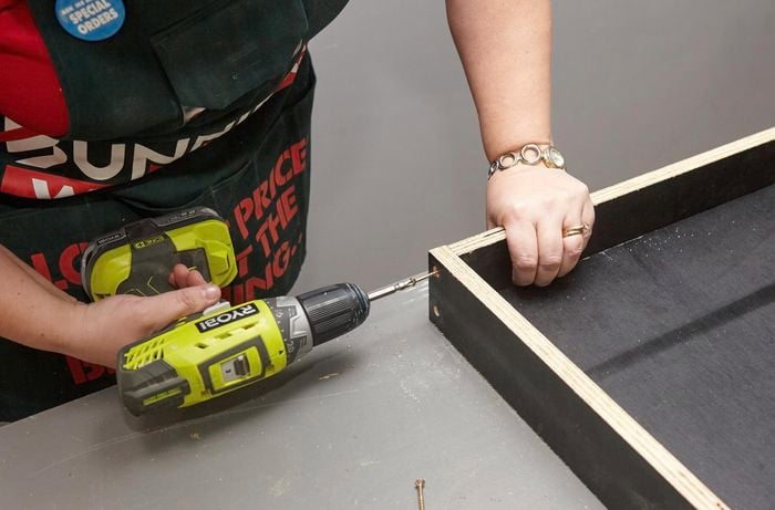 Person drilling form ply frame side together.