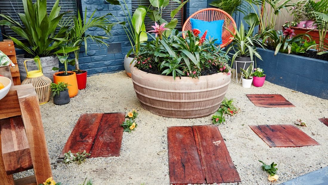 Front yard with pot plants and chairs in a modern setting.